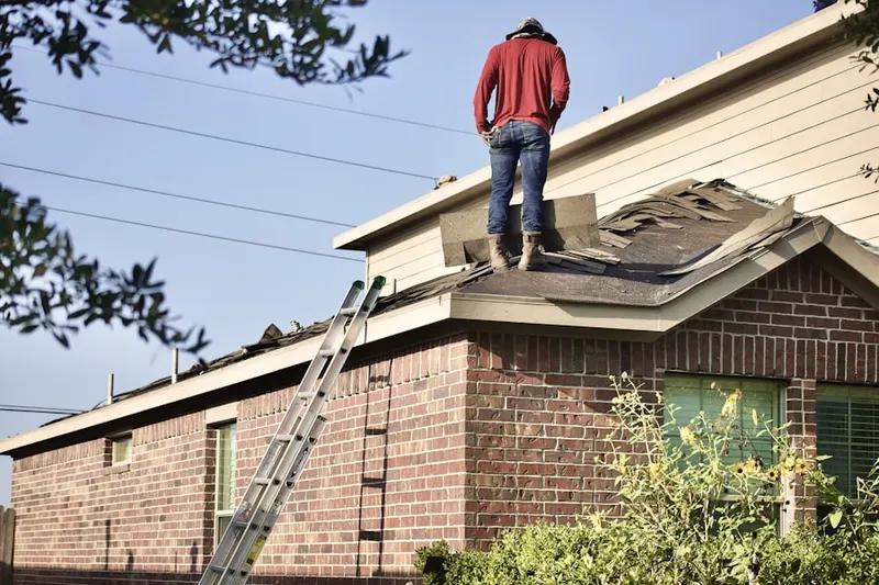 Professional roofer working on a residential roof in Tisbury